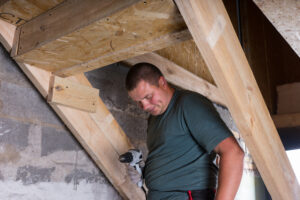 builder with drill building stairs in basement